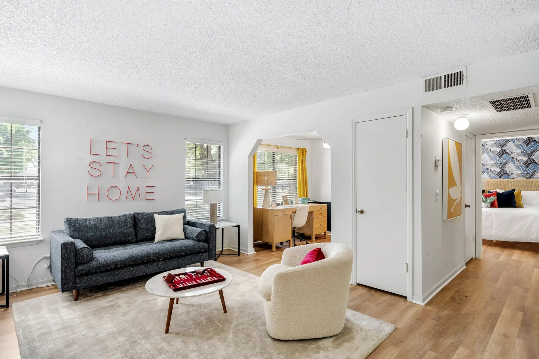 Open concept living room with large windows and desk/office nook